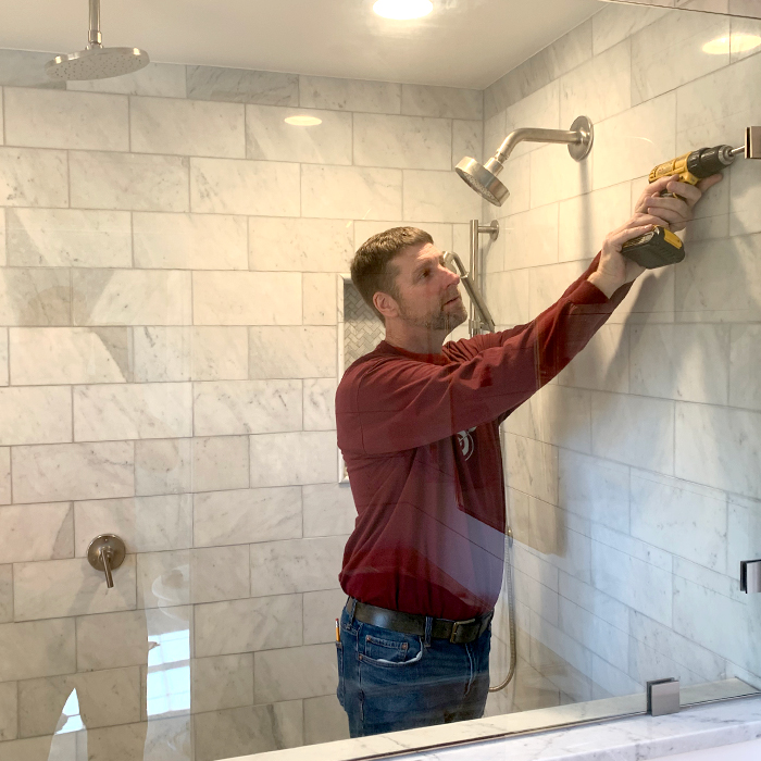 Rick Powles, Owner of Nu-Glass & Storefronts, installing a frameless shower enclosure